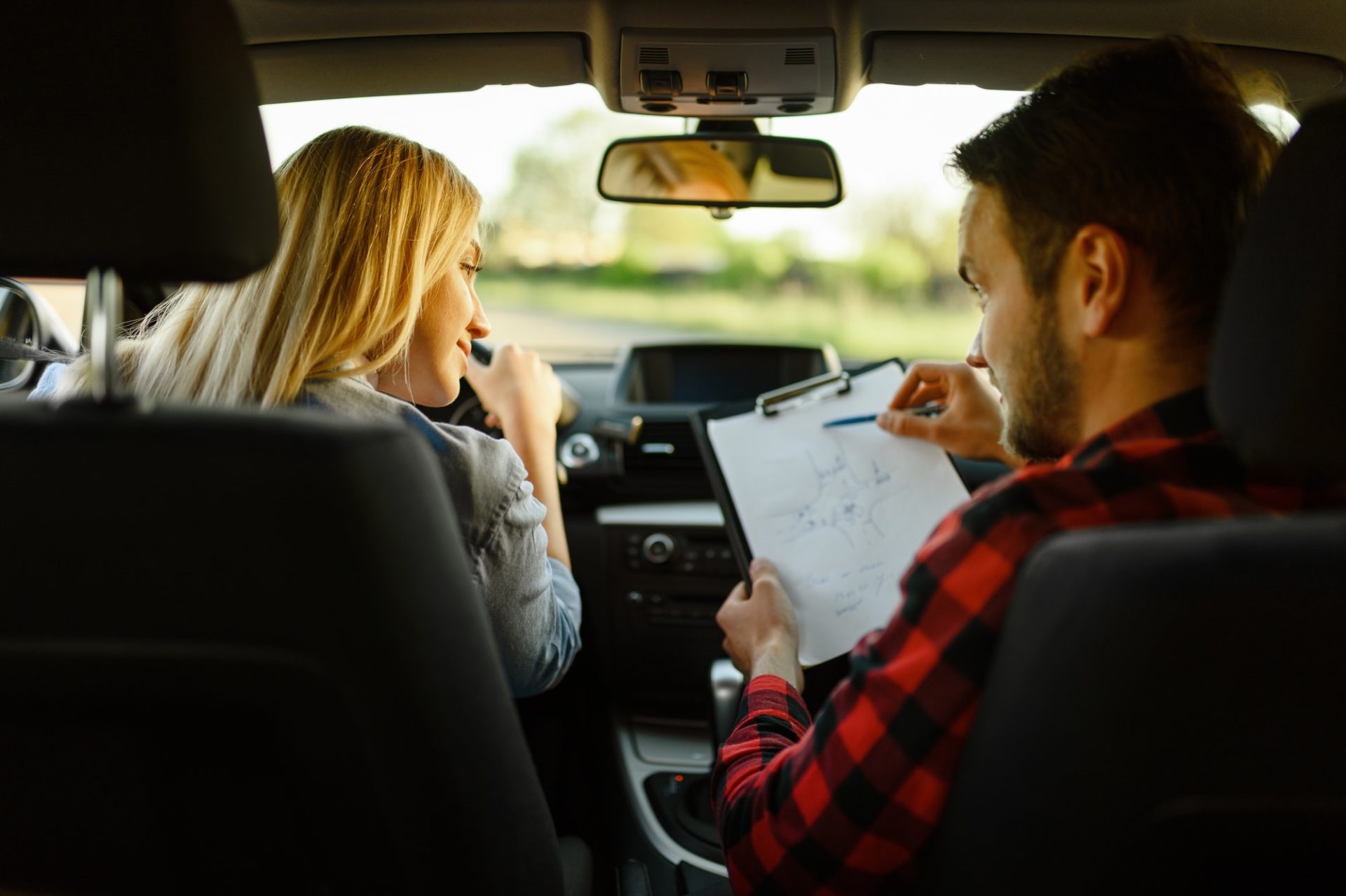 instructor-helps-woman-to-drive-the-car-e1627375431416.jpg